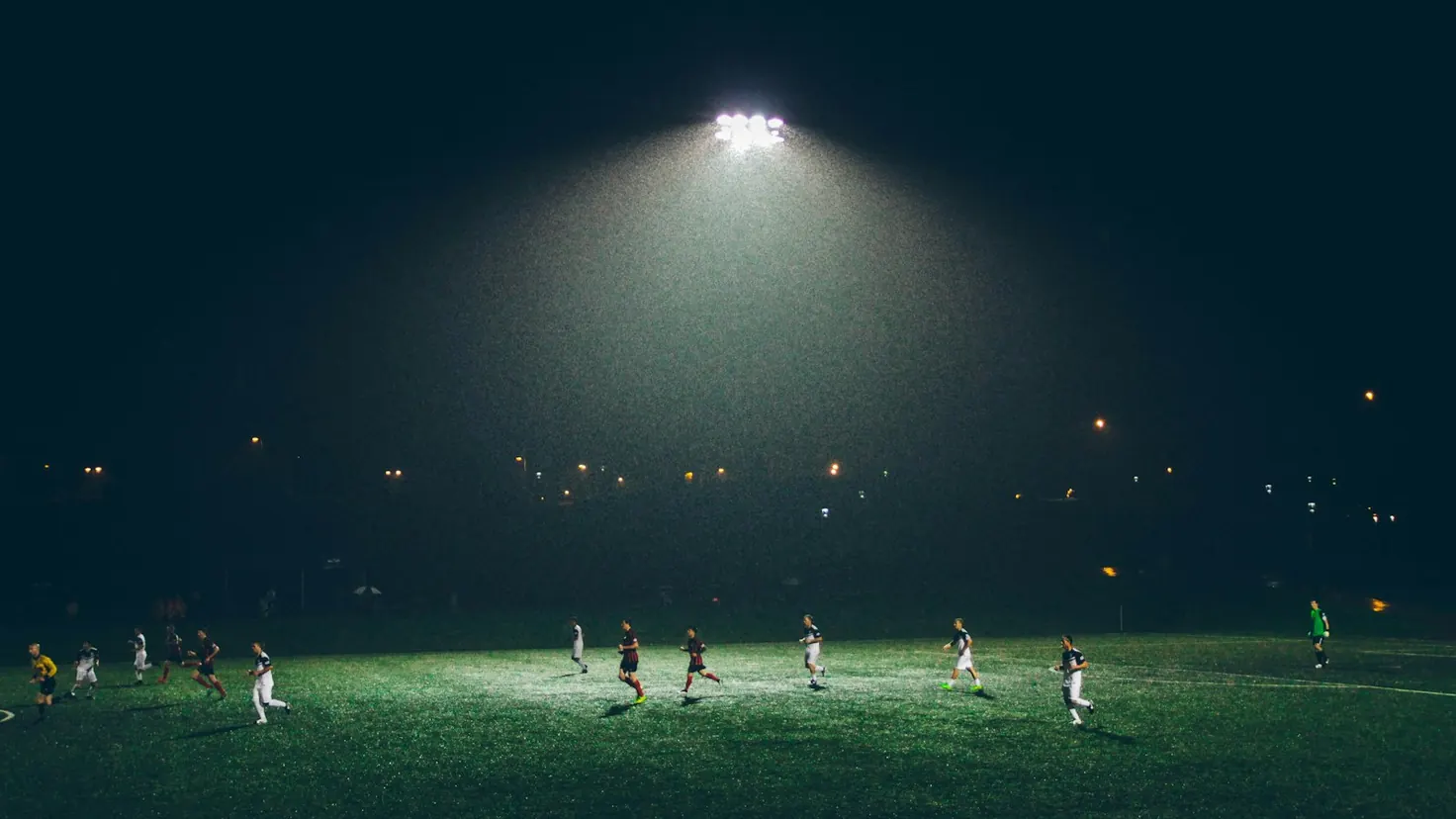 Stade de football éclairé en pleine partie, illustrant le business du football et l’argent de la Coupe du Monde 2026