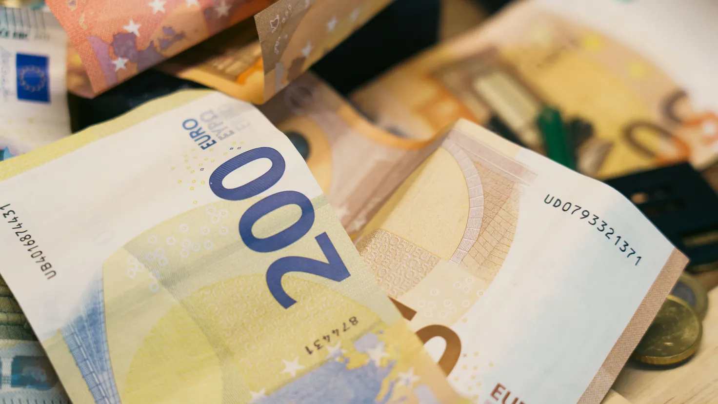 Billets de 200 et 500 euros et quelques pièces posés sur une table en bois à domicile, illustration de la question combien d'argent liquide peut-on légalement garder chez soi en France en 2026