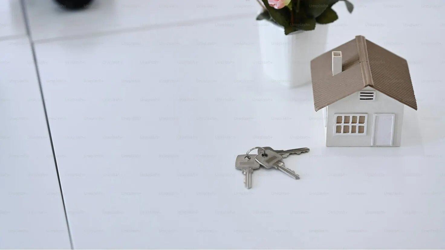 Maison miniature et clés sur une table, illustration du crédit immobilier à taux bas et de la décision de garder son bien immobilier en 2026