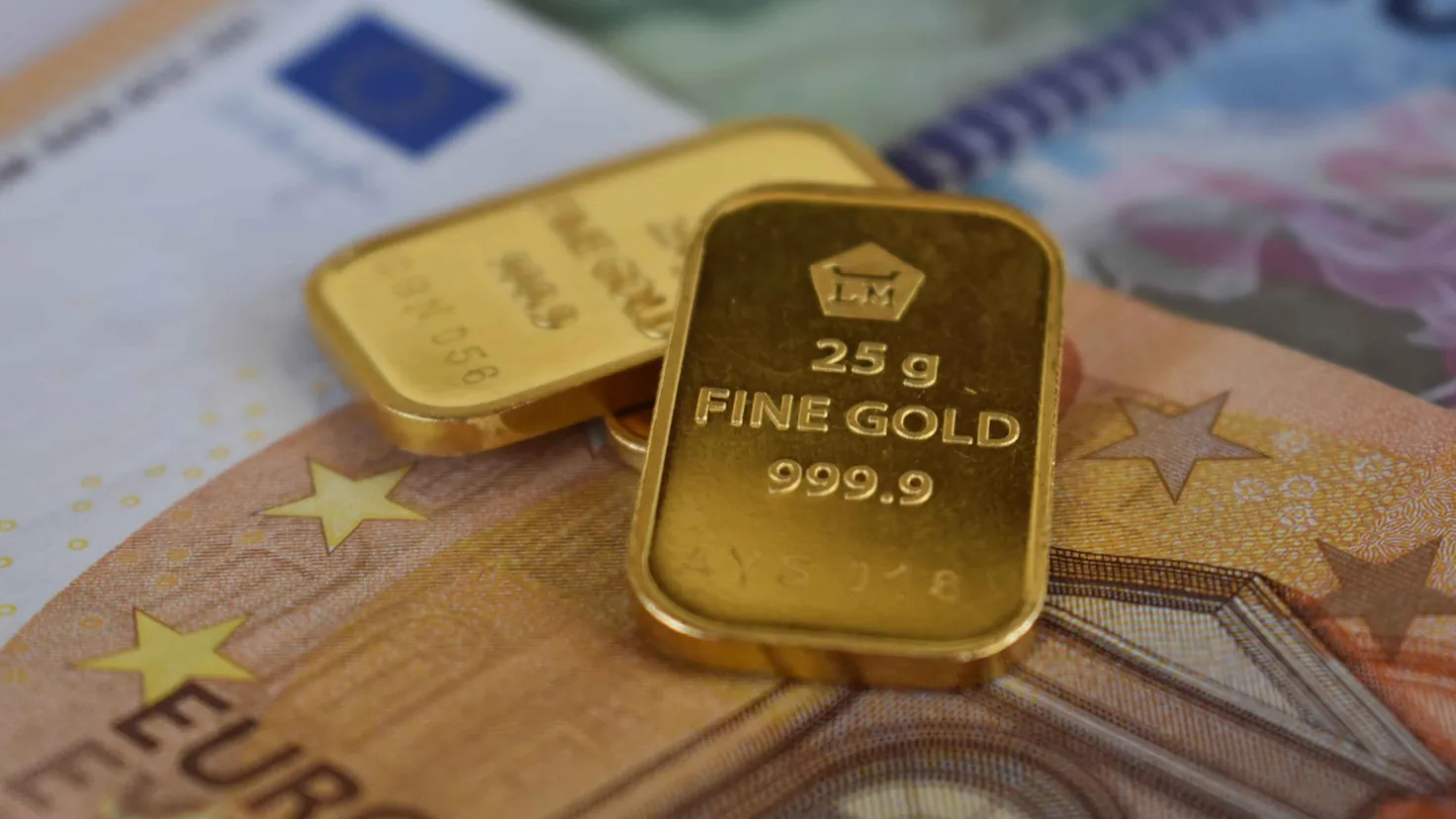 Fiscalité de l'or : deux lingots d'or fin 999,9 posés sur des billets en euros, illustration de la taxe à la revente de l'or physique et des deux régimes d'imposition en 2026