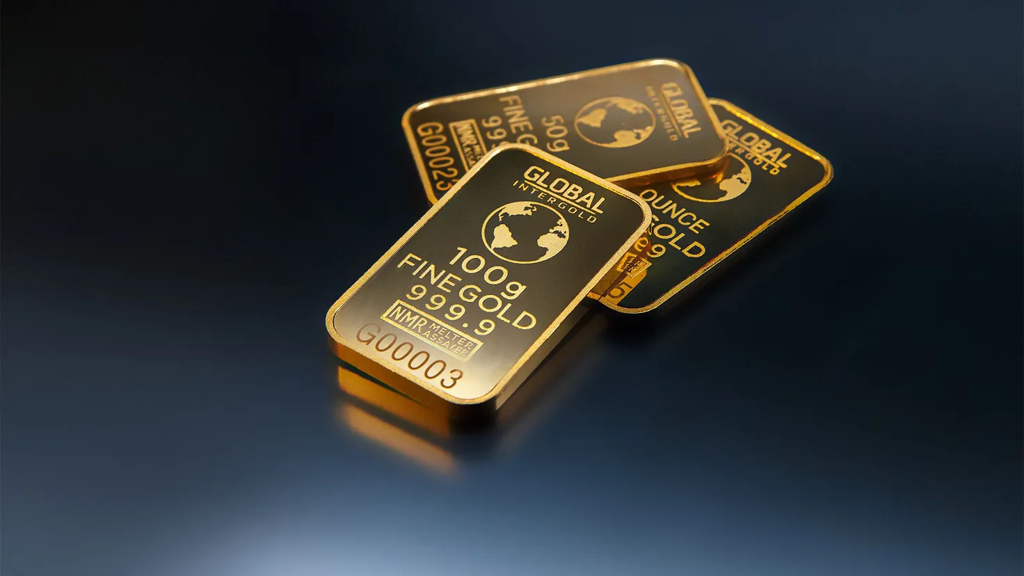 Lingots d'or fin posés sur fond sombre, illustrant l'investissement dans les matières premières en 2026 via un ETF