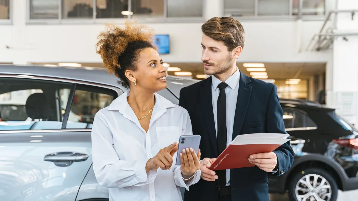 LOA ou LLD ou achat : un conducteur compare le coût réel d'un financement auto face à une fiche de loyers en concession