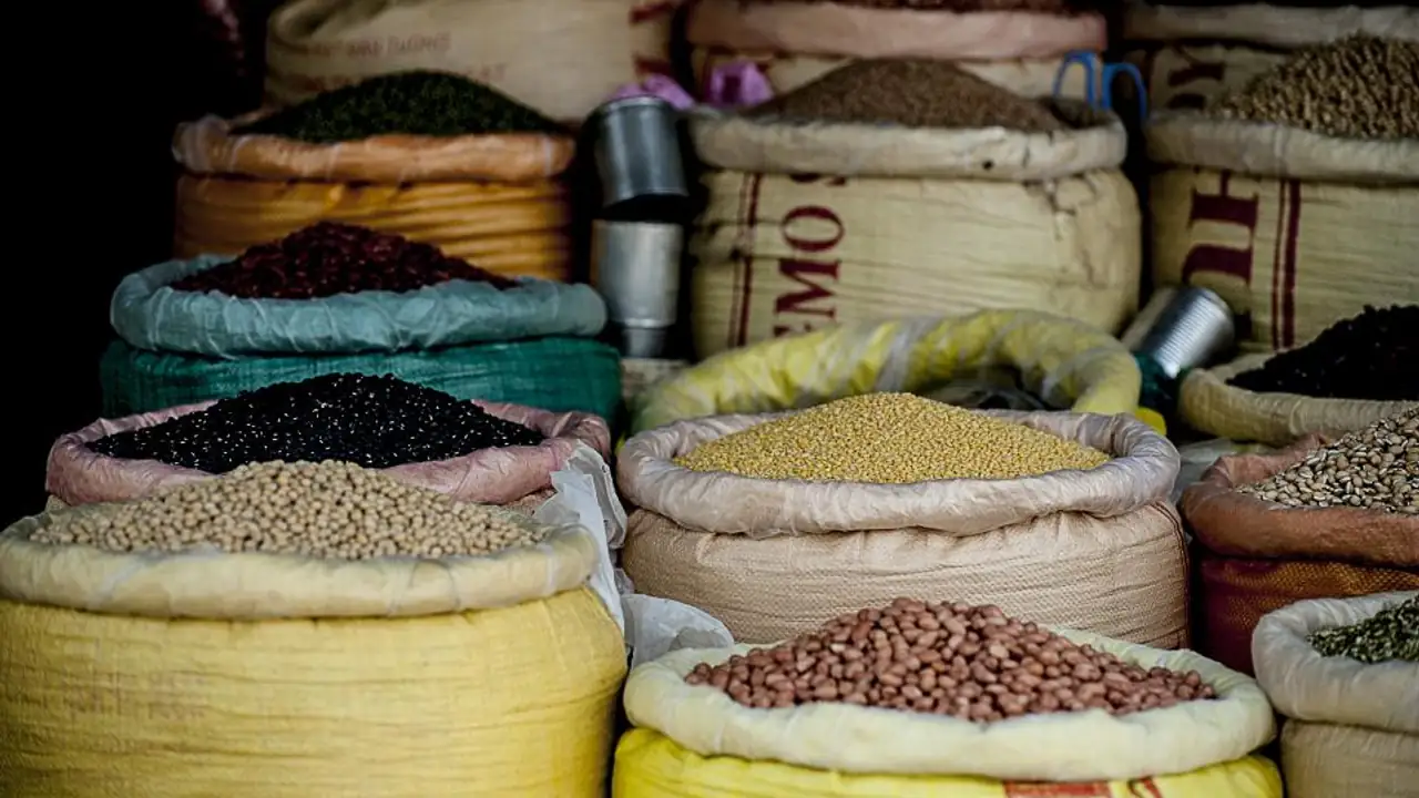 Sacs ouverts de légumineuses en vrac sur un marché : haricots noirs, pois cassés jaunes, pois chiches et lentilles