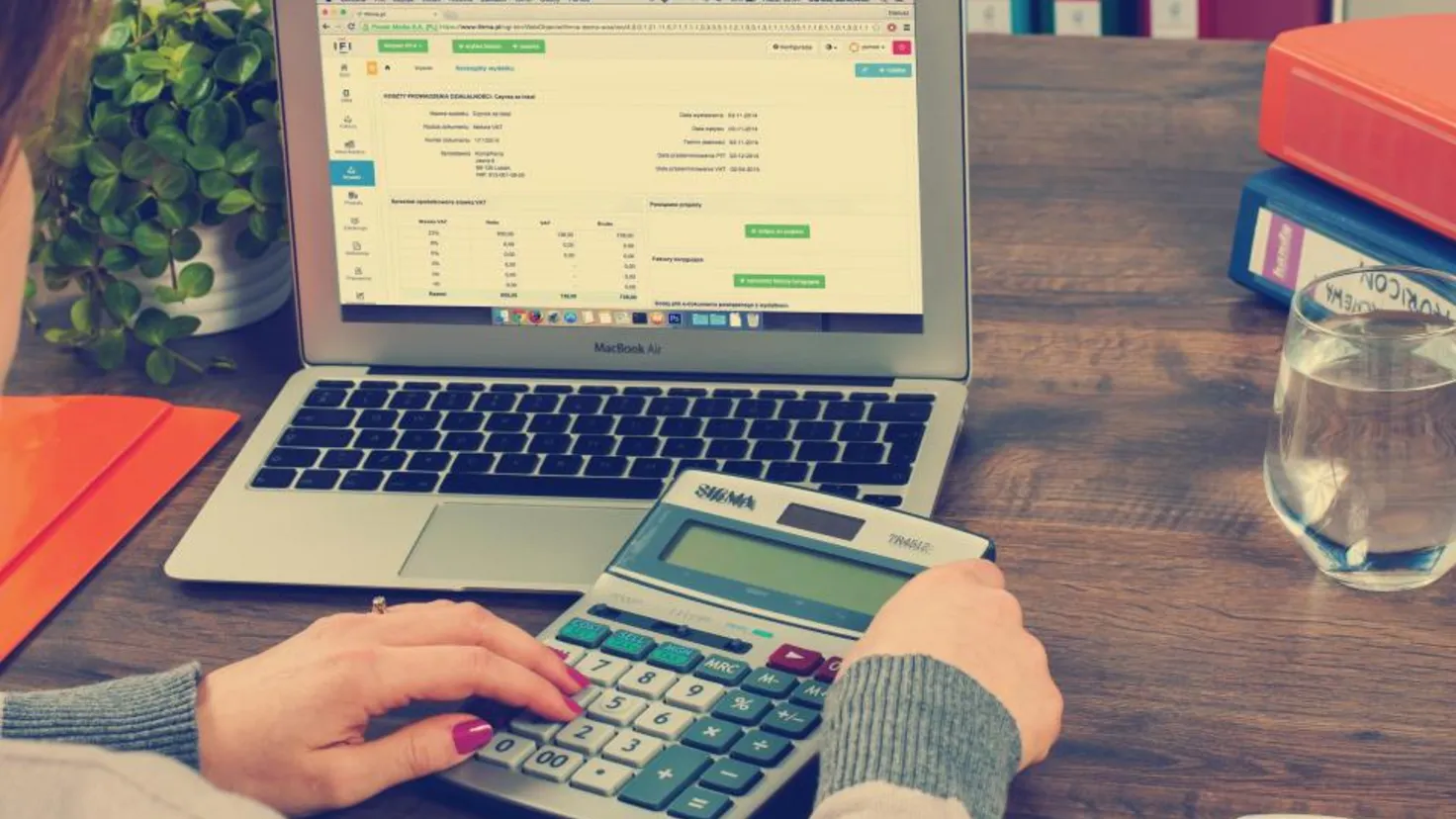 Calculatrice et documents financiers posés sur un bureau pour estimer la taxe PUMA d'un rentier en 2026